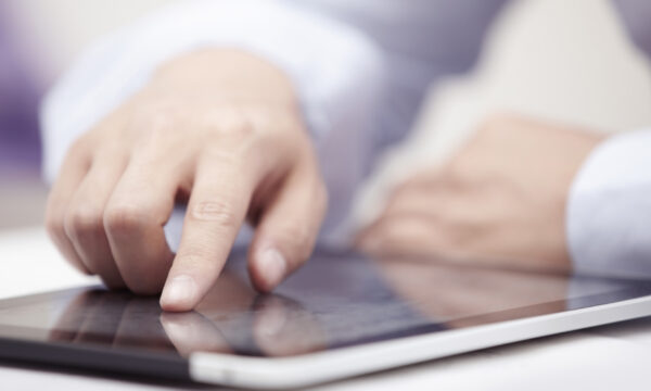 Hands of businessman using tablet PC at office